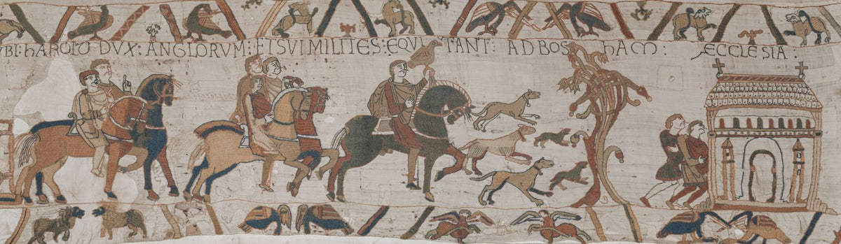 A closeup of a panel from the Bayeux Tapestry, with a Medieval man on a horse surrounded by dogs.